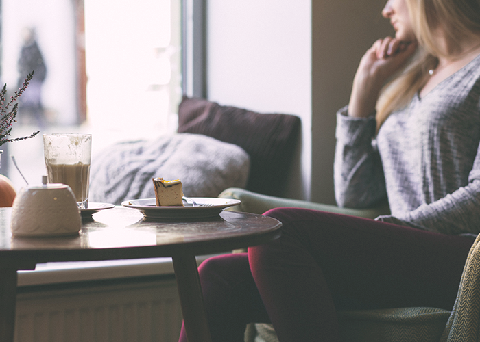 woman-sitting-by-couch-looking-out-window