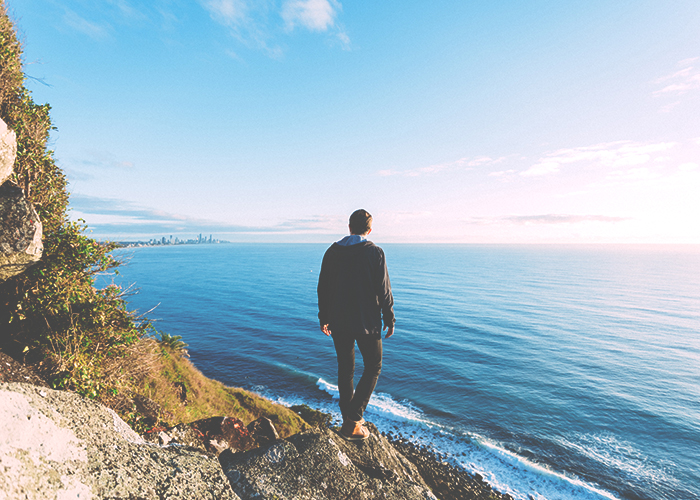 man-standing-on-coast-on-cliff