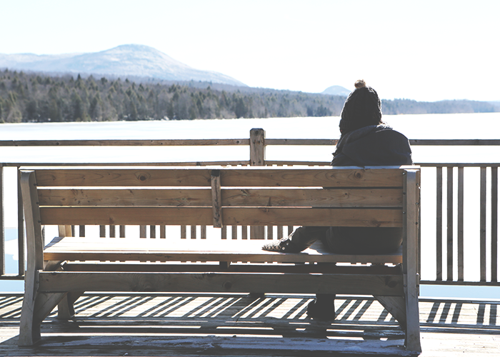 young-women-sitting-on-bench-near-lake