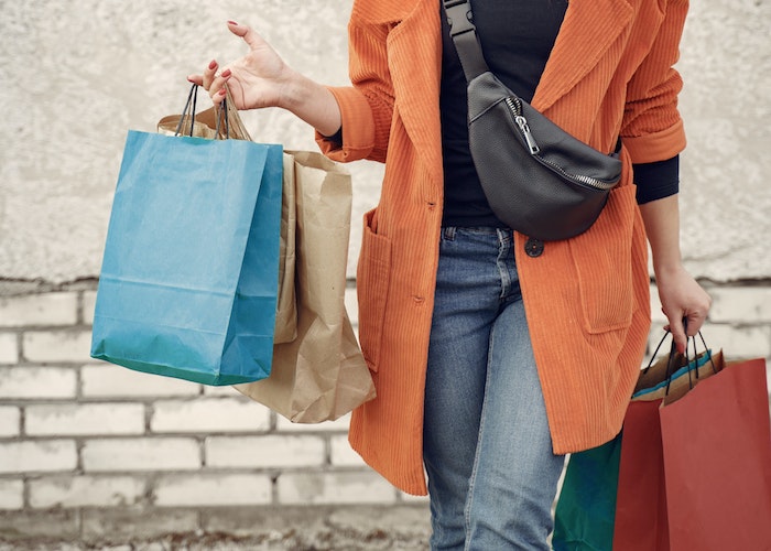woman-holding-shopping-bags-with-orange-blazer