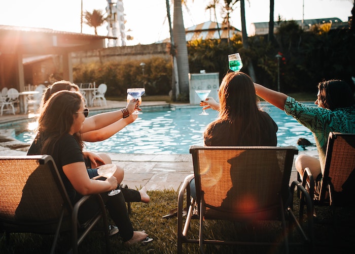 Image of woman toasting by poolside